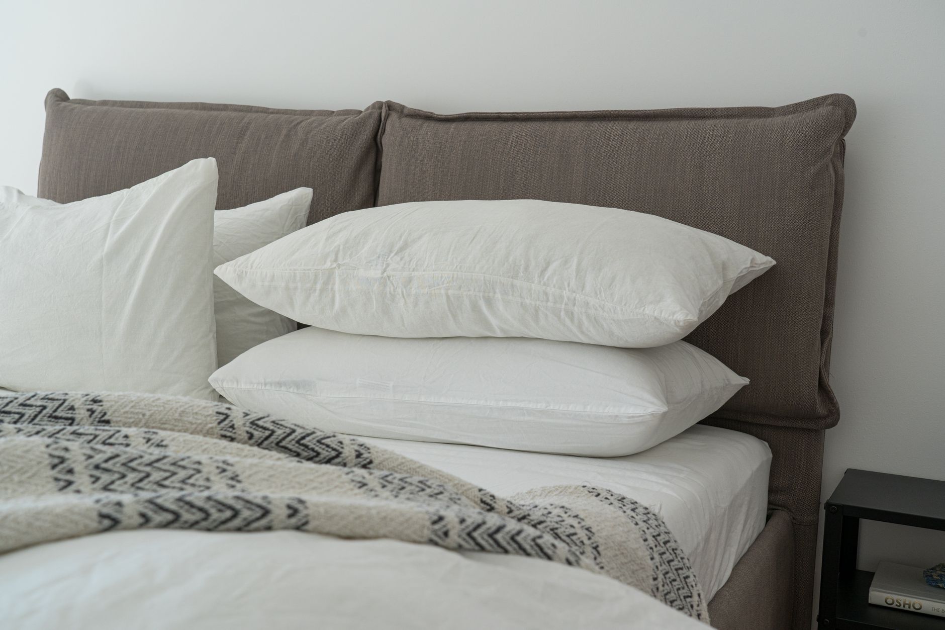 two queen mattresses side by side in a bedroom, one showing slight surface wear