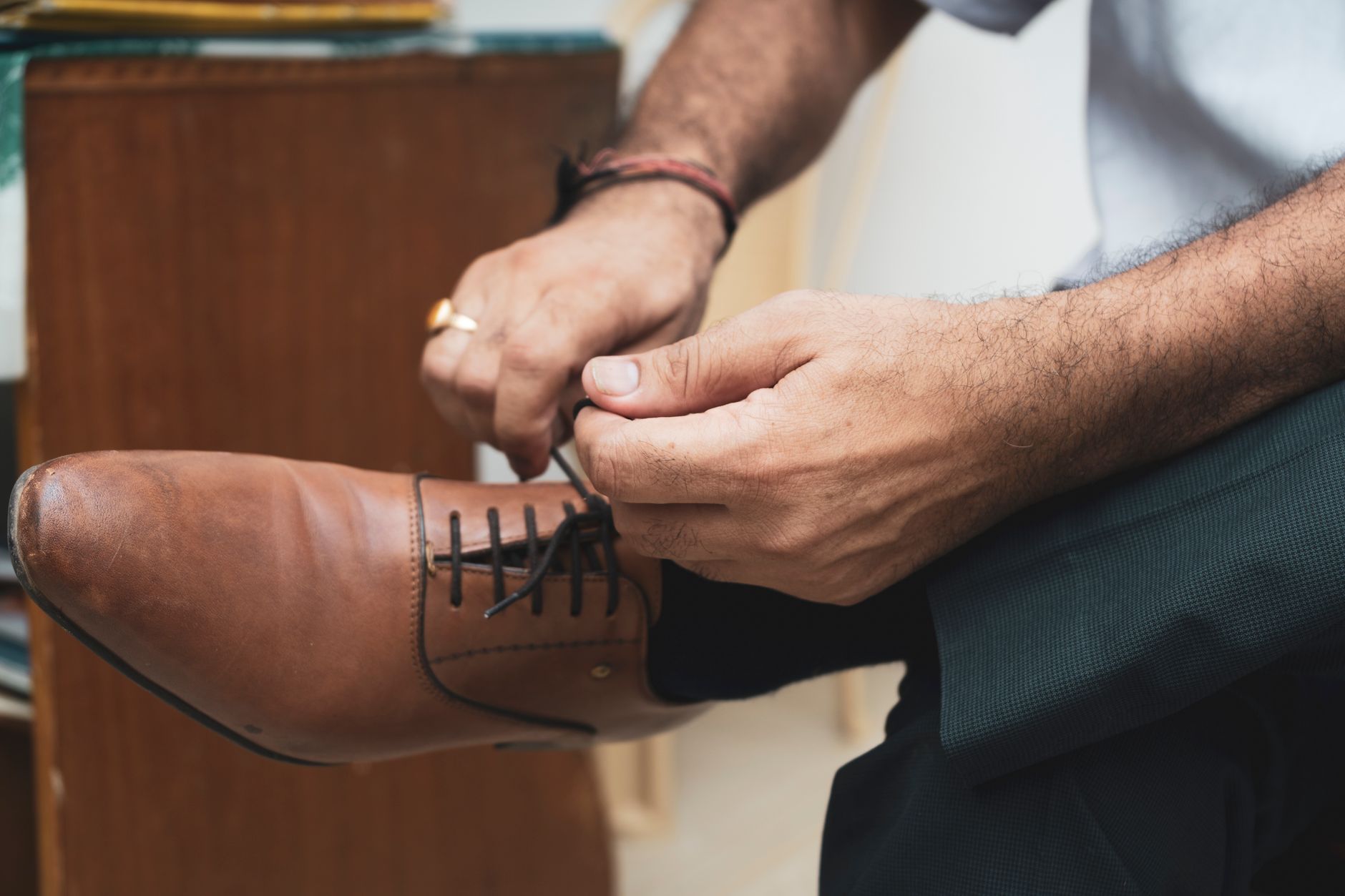 A close-up of a man's hand pulling at the leg hem of a dark performance boxer brief, showing the silicone grip strip and the fabric's stretch.
