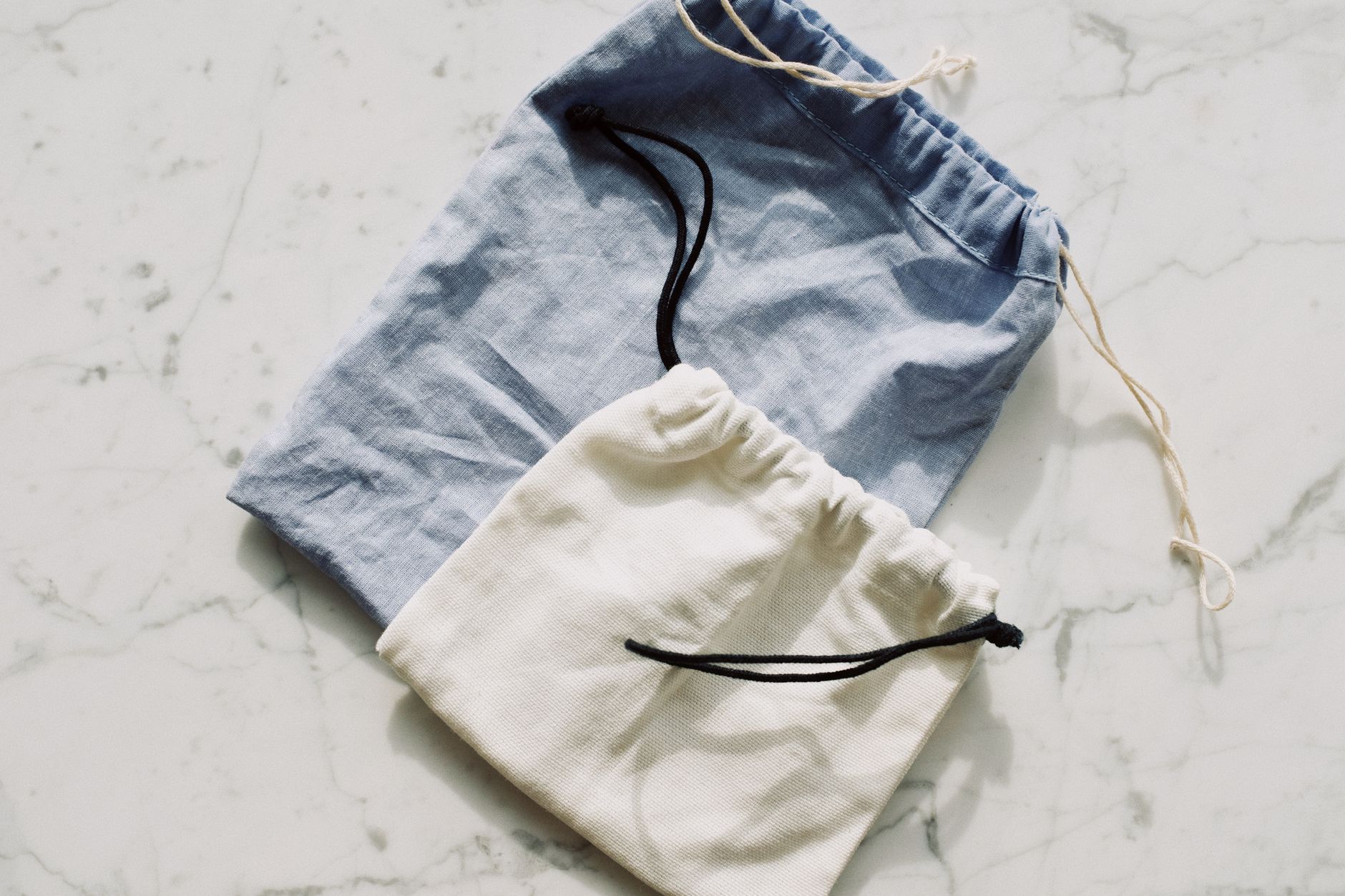 a split-screen of two pairs of underwear laid flat, one with a structured pouch and one with a smooth front, with a tailor's tape measuring inseam
